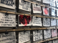 Shelves of fun bags with quotes by local artisan in NYC at Bryant Park Winter Village