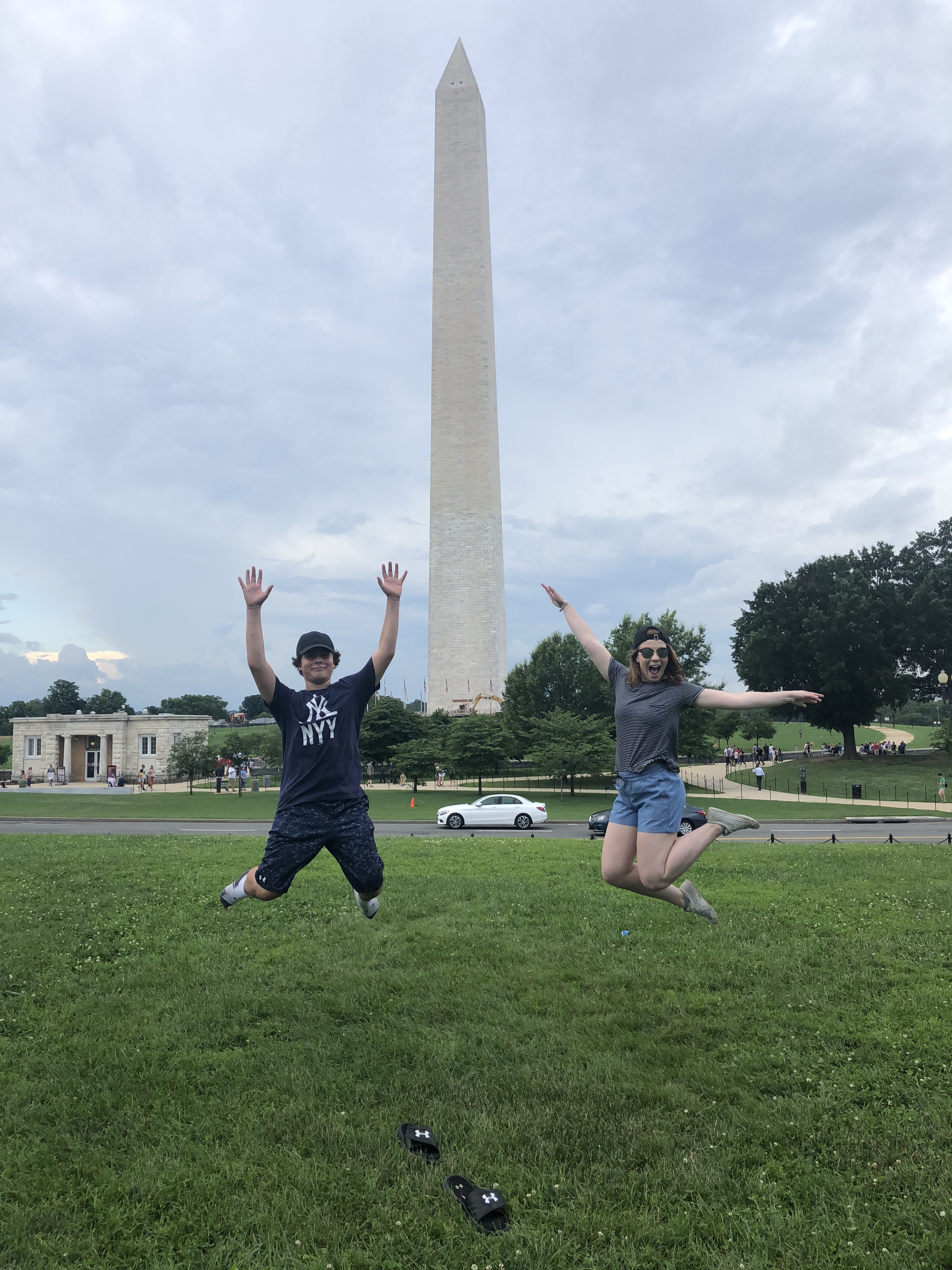 Two people jumping for joy in front of Washington Monument, D.C.